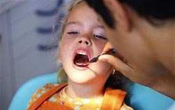Dentista revisándole la boca a una niña